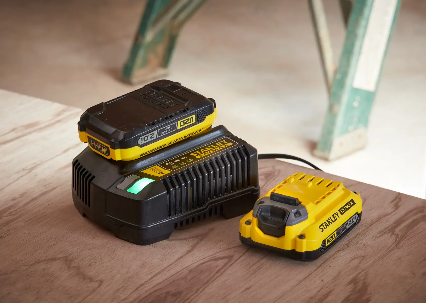 STANLEY SC200, SC200-B2, SC200-B3, SC200-KR, SC200-BR, SC200-B1 cargador y batería sobre mesa de madera.