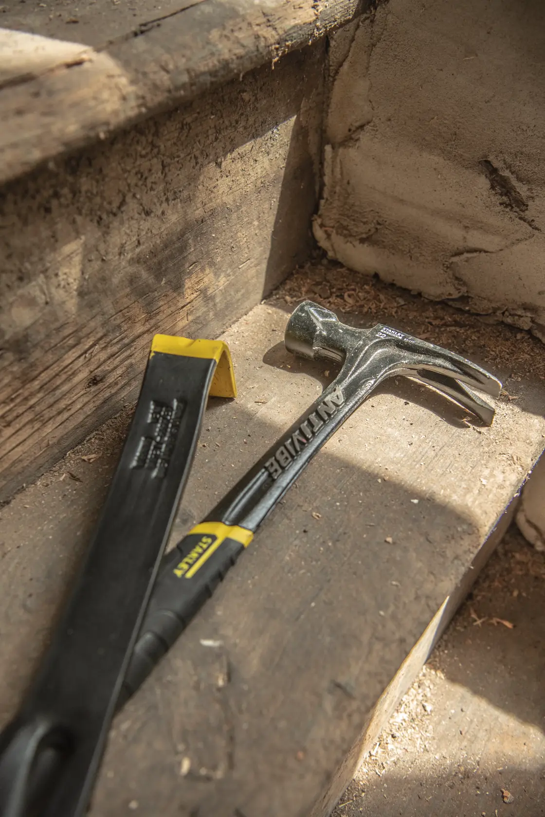 STANLEY 55-515 barra de uña y martillo sobre escalones de madera, ángulo en primer plano.