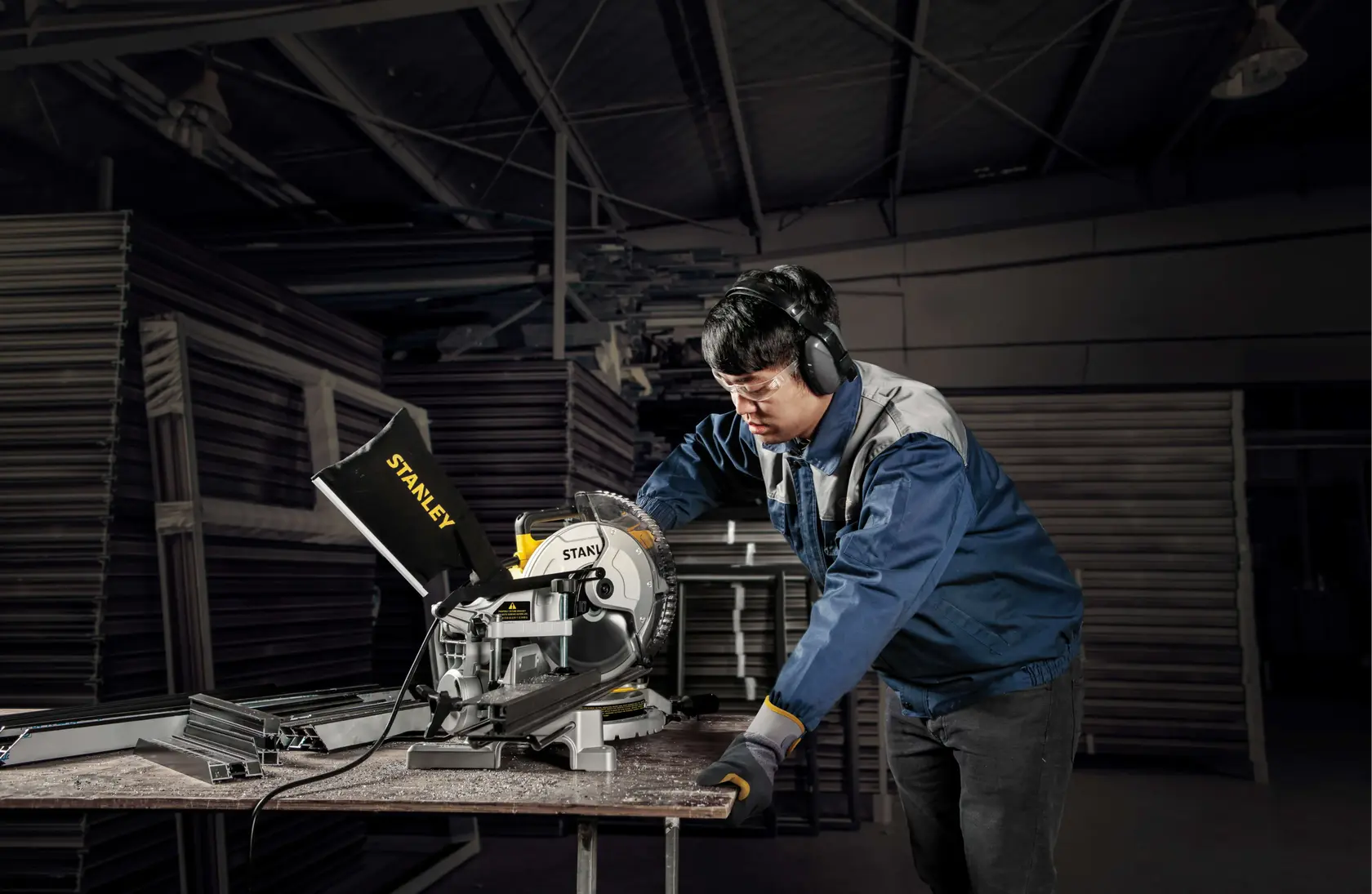 Fotografía de sierra ingletadora STANLEY SM16-B3 en uso por trabajador en taller industrial.